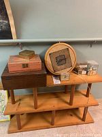 Overall view of wood shelf with shelves holding clocks, matchbooks, and jewelry boxes.