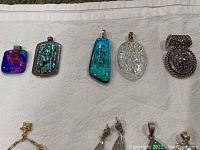 7 pendants including colorful glass or synthetic stones and a silver-tone metal piece, 2 decorative rings