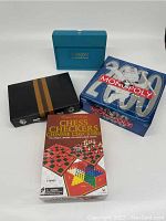 Lot contents showing all games and puzzles including Monopoly Millennium Edition, chess, checkers, Chinese checkers set, and travel Scrabble case