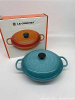 Shallow casserole with lid in front of Le Creuset box