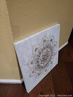 Large square canvas leaning against a wall showing full mandala design.