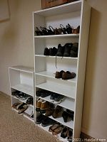 Two white shelving units, one shorter 2-tier and one taller 5-tier, both used for shoe storage with multiple pairs of shoes visible on shelves.