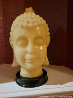 Front view of cream colored Buddha bust sculpture showing serene face and detailed hair curls.