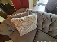 Close-up of tufted back and stacked pillows showing fabric texture and pattern