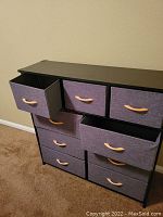 Close-up view of dresser showing drawer pulled halfway out, fabric drawer construction and wooden handle detail.