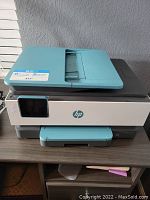 Front view of HP OfficeJet Pro 8028 printer showing the control touchscreen, paper output tray, and overall design.