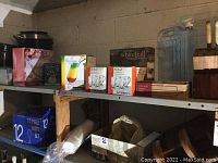 Various boxed glassware sets including Luminarc 12-piece flute set, summer-themed glasses, hurricane glasses, and other kitchen items on basement shelves