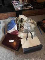 Photo of bags, briefcases, and folded linens grouped on the floor.