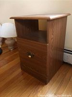 Full view of the wood side table showing the top, open shelf, and file drawer.