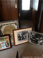 Wide shot of three framed sports posters leaning against wall