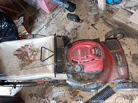 Top-down view of Toro Recycler lawn mower with grass collection bag filled with leaves and debris. Unit is in used condition with visible dirt and dust.