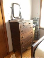 Full view of vintage wooden dresser with mirror on top in room corner