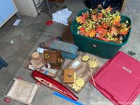 Overview of lot showing toys, wooden birdhouse, flower decorations, and bin of faux leaves