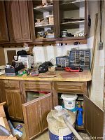 Work area showing tools, hardware organizer, radio on kitchen counter