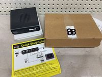 Digital to analog converter box shown with quick start guide and original box.