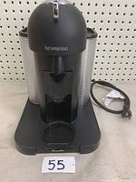 Front view of Breville Nespresso coffee maker showing the main spout, drip tray, and power cord.