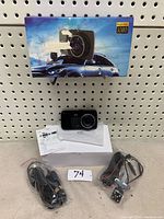 Image of the full lot showing dash cam, rear camera with cables, white box and the product packaging box behind.