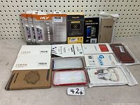 Overview of various sealed cell phone accessories including cases, battery packs, and screen glass protectors laid out on a surface.