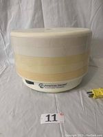 Front and side view of assembled American Harvest FD50 dehydrator showing lid, stacked 5 trays and base unit with logo and model.