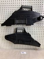 Two black DELCO Tools drywall tape tools positioned vertically on pegboard, showing side profile with handle and strap, branding visible.