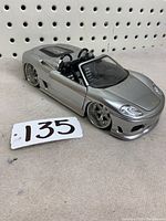Silver Hot Wheels Ferrari 360 Spyder 1/24 scale metal model viewed from driver's side with closed doors and hood.