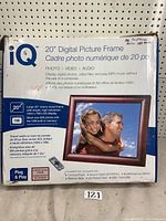 iQ 20 inch digital picture frame box front showing features including 1024x768 resolution, 1GB built-in memory, compatible with multiple media formats, plug and play feature, and cherry wood frame.