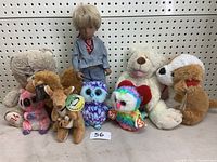Photo showing entire lot of 8 plush toys including teddy bears, a doll, owls, dog, deer, and colorful bird.