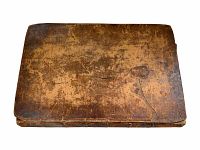 Front leather cover of the antique book showing wear, cracks, and aging on cover surface.
