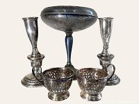 Photo showing the full lot with the compote, two candle holders, and pair of cup holders arranged against light backdrop.