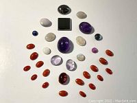 Top-down photo showing cabochons arranged in a pattern on white background.