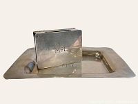 Handmade sterling silver match case and ashtray engraved 'MCC' set photographed together showing the match case standing inside the ashtray groove.
