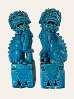 Front and side view of the pair of bright blue ceramic Foo Dog statues showing facial and body detail including collar and base design.