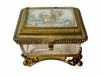 View of the vanity box showing the hand-painted lid and gold-tone detailed metal frame with clear glass sides.