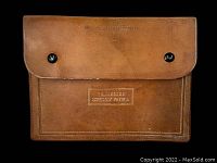 Front view of brown leather clutch with TN Highway Patrol embossing and black button snaps.