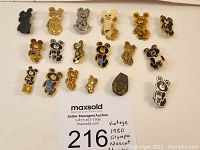 Lot of 18 vintage 1980 Moscow Olympic Misha Bear pins arranged on table with auction label
