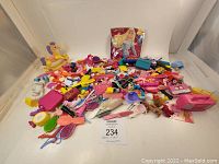 Full lot of over 340 Barbie doll accessories including brushes, combs, mini furniture, and toys in a variety of colors