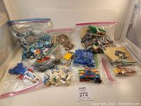 Wide view of all bags containing various loose LEGO bricks and pieces in different colors and shapes including specialty parts.