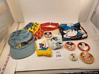 Photo showing all items including shirt, three hats, two pairs of socks, and four buttons arranged neatly