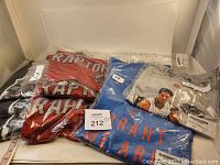 Stack of 4 Raptors T-shirts on left, plus one blue Durant and one grey Davis shirt on right, all in original packaging