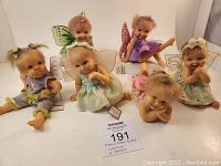 Overview of all 6 Precious Pixies fairy figurines displaying a variety of wing colors and dress shades, grouped on a white surface