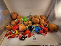 Wide view of Potato Head bodies and assorted accessory pieces in brown, red, blue, yellow, pink, black, white, and green plastic