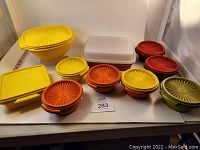Photo showing 20 vintage Tupperware pieces including various colors and shapes with lids