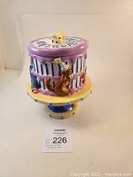 Side view of the Winnie the Pooh birthday cake cookie jar showing character details and color scheme.