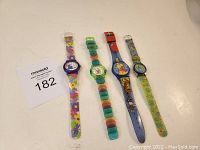 Four different Winnie the Pooh themed children's wristwatches displayed side by side showing entire length of bands.