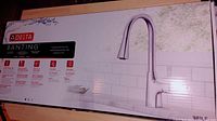 Box of Delta Banting kitchen faucet showing product image with faucet and chrome finish