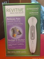 Box front showing product branding and key features including pain relief and healing support, ultrasound therapy, drug-free device.