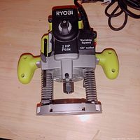 Front top view showing Ryobi logo, 2 HP Peak marking, variable speed dial, and 1/2 inch collet base.