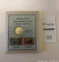 Front view of sealed display case showing silver half dollar and two stamps with text 'America's First Commemorative Coin & Stamp Collection'