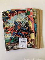 Photo showing the stack of five vintage Superman and related DC Comics comic books including Superman No. 33 July 1989 and others, front covers and spines visible.