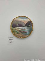 Full view of the antique hand-painted Limoges plate showing gold trimmed scalloped edge and Delaware Water Gap river scene with boats and mountains.